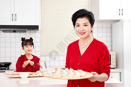 厨房里奶奶端着包好的饺子图片