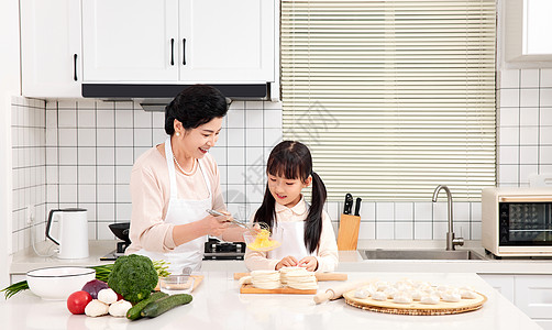 奶奶和孙女一起在厨房包饺子图片