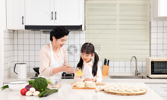 奶奶和孙女一起在厨房包饺子图片