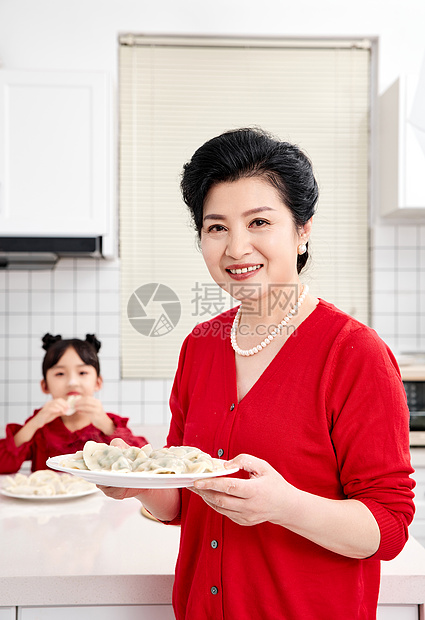 厨房里奶奶端着煮好的饺子图片