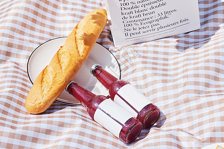 野餐垫上的饮料和法棍面包图片