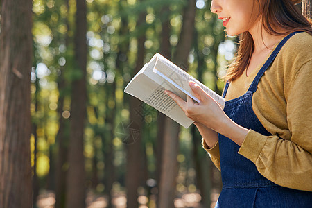 美女大学生公园里郊游看书阅读特写图片