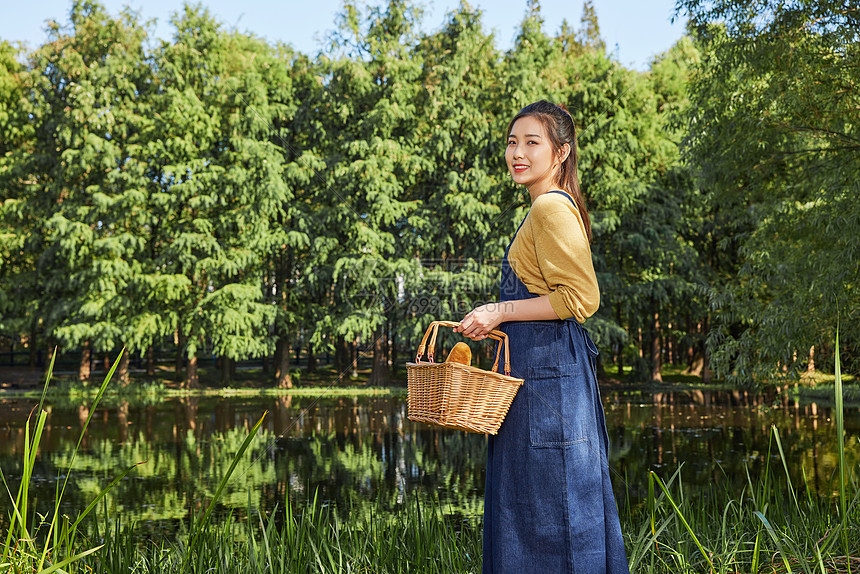 青年美女公园湖边郊游提着篮子图片