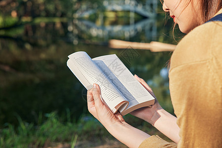 美女大学生公园湖边看书阅读特写图片
