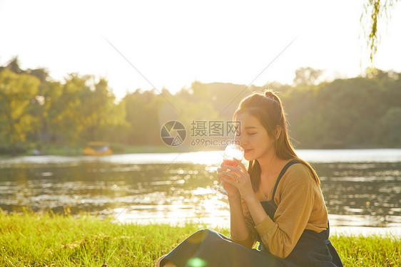 傍晚黄昏公园美女野餐喝酒图片