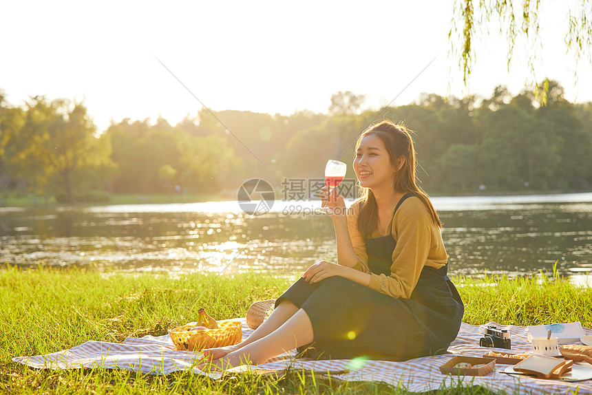 傍晚黄昏公园美女野餐举杯喝酒图片