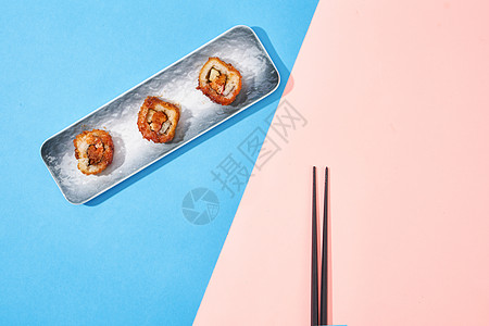 蓝粉撞色背景下的寿司卷背景图片