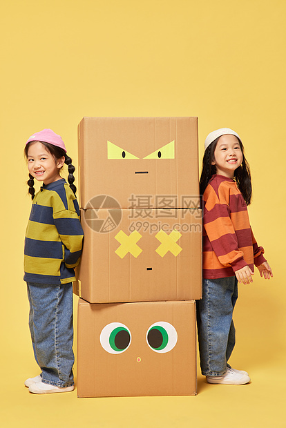 双胞胎小女孩躲在创意纸盒箱旁边图片