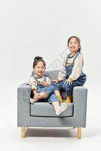 双胞胎小女孩居家沙发上亲密陪伴图片