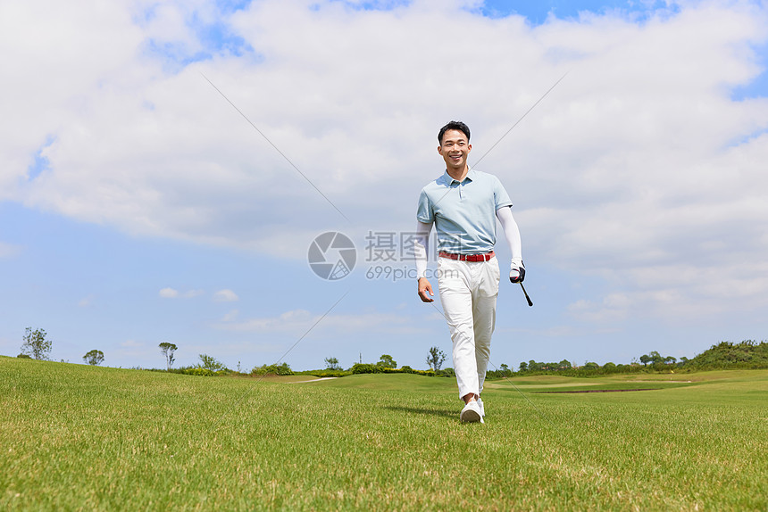 走在高尔夫球场的男性图片