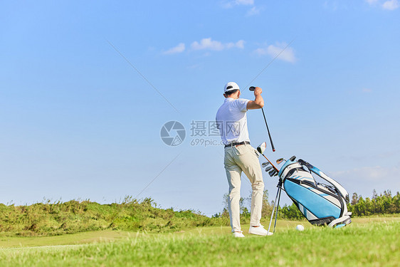 男性收拾高尔夫球杆背影图片