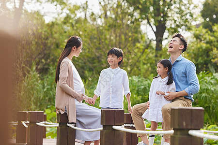 三胎夫妻带着孩子湖边散步图片