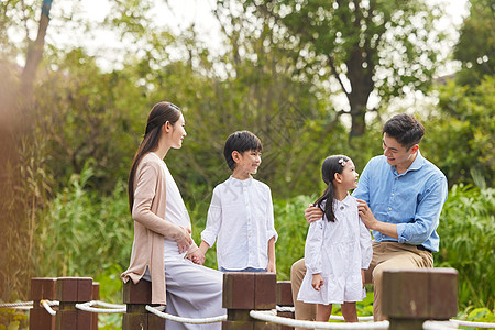 三胎夫妻带着孩子湖边散步图片