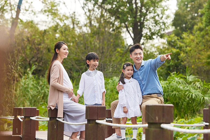 三胎夫妻带着孩子湖边散步图片