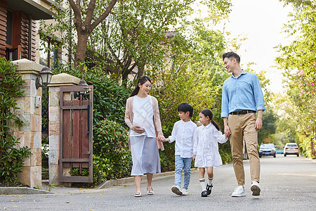 三胎夫妻带着孩子小区里散步图片