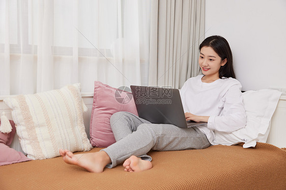 美女居家趴在沙发上用笔记本电脑网购图片