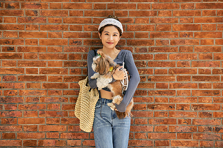 清新美女抱着宠物狗出游逛街图片