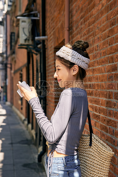 清新美女出游逛街拿相机拍照图片