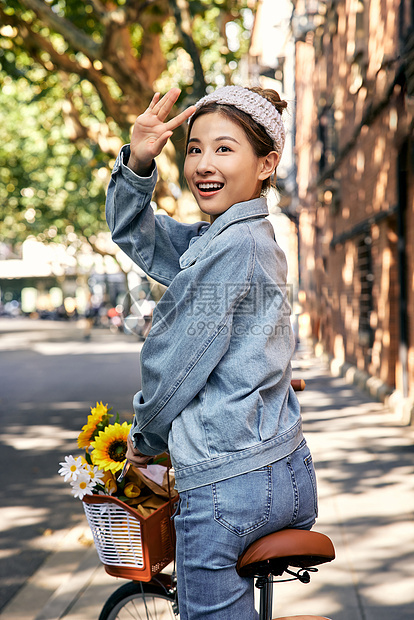 清新美女骑自行车出游逛街回头微笑图片