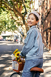 清新美女骑自行车出游逛街回头微笑图片