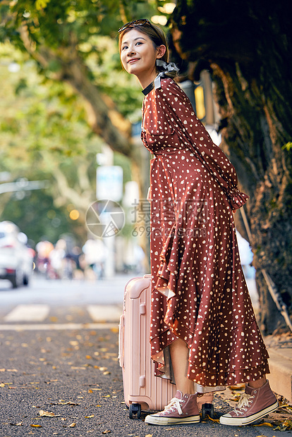 清新美女拉行李箱路边等车图片