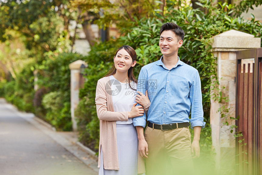 高档小区散步的年轻夫妇图片