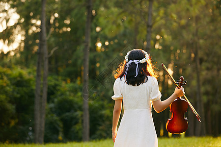 夕阳下拿着小提琴少女的背影图片
