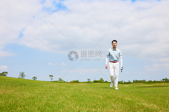 走在高尔夫球场的男性图片