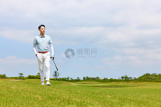走在高尔夫球场的男性图片