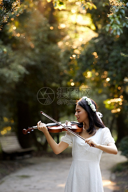 夕阳余晖中拉小提琴的少女图片