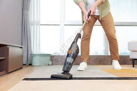 单身男性年轻男性居家使用吸尘器清洁地毯特写背景