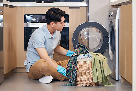 年轻男性居家使用洗衣机洗衣服图片
