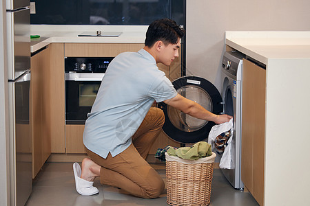 年轻男士在家使用洗衣机洗衣服图片