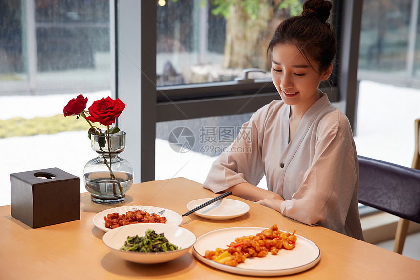 青年美女在汤泉馆美食区享用美食图片