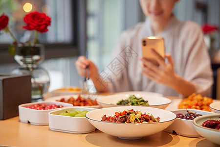 秋季饮食青年女性在汤泉馆吃饭玩手机特写背景