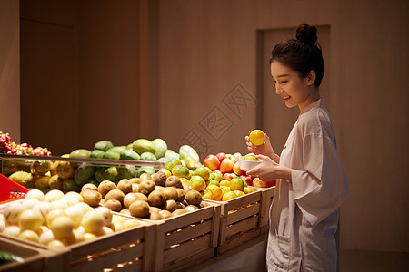 在美食区挑选水果的女性图片