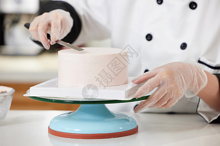 烘焙师使用刮刀抹奶油特写背景图片
