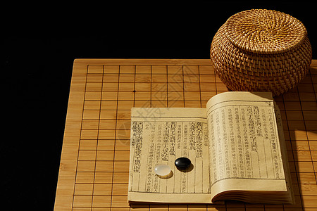 一书一叶元素围棋棋盘上的棋子和书背景