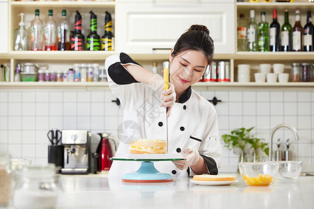做糕点的女人女性烘焙师使用刮刀抹奶油背景