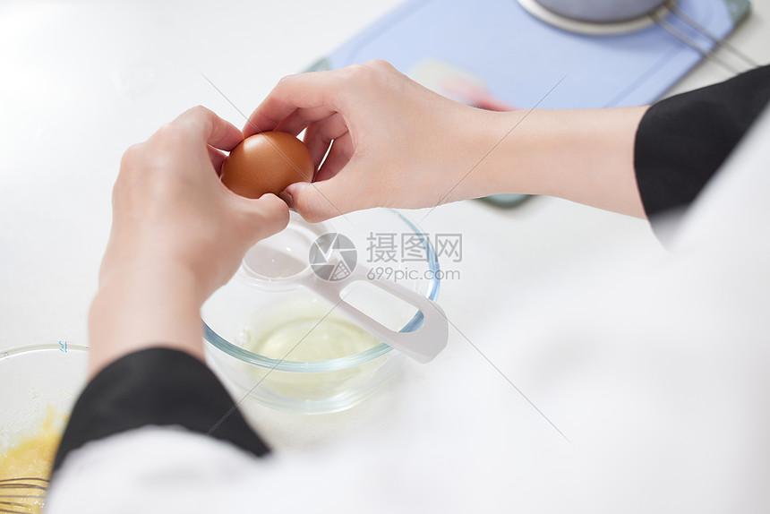 烘焙师制作面点打鸡蛋特写图片