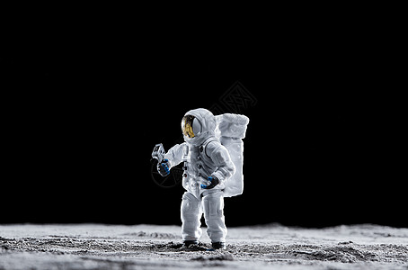 站在月球表面手拿探测器的宇航员背景图片