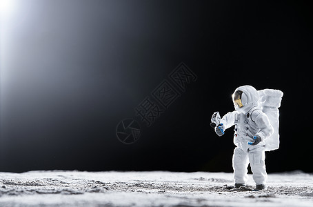 载人航天站在月球表面手拿探测器的宇航员背景
