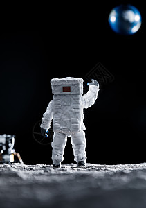 商务人士背影宇航员太空登月面朝地球挥手致意背景