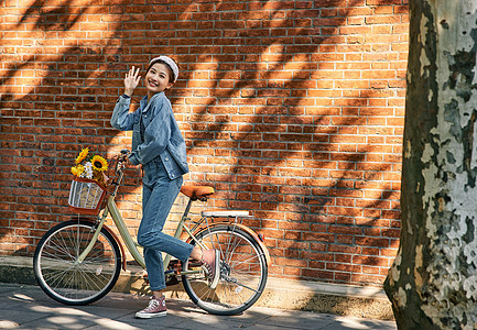 清新美女骑自行车出游逛街打招呼图片