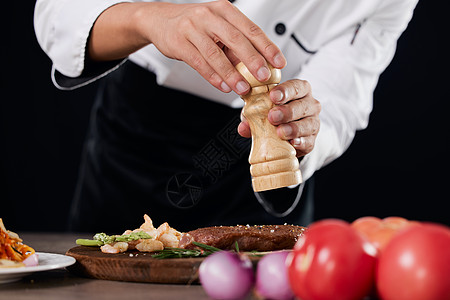 厨师给食物调味特写图片