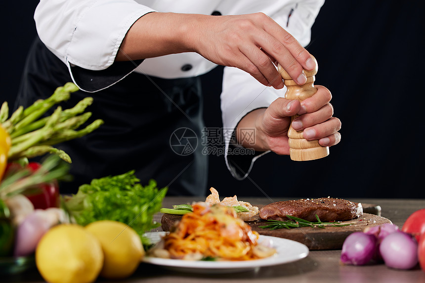 厨师给食物调味特写图片