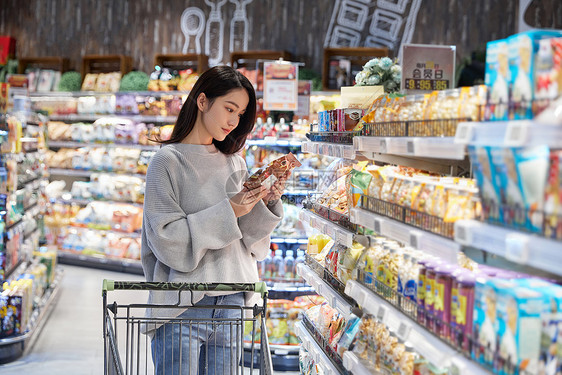 青年女性逛超市采购挑选商品图片