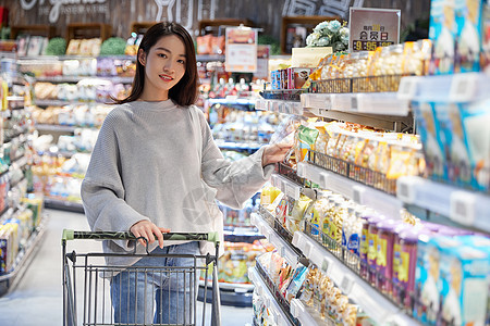 青年女性逛超市采购挑选商品图片