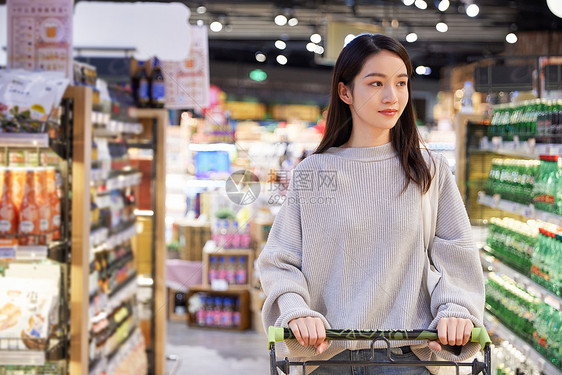 青年女性推手推车逛超市购物图片