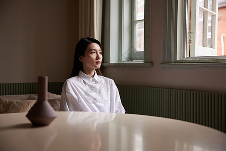插花文艺成熟女性坐在家中客厅发呆思考背景
